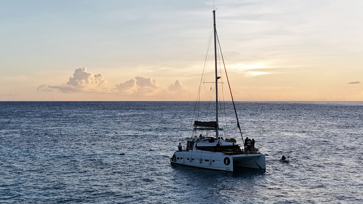 사이판 서태평양의 붉은 노을 속 요트 항해