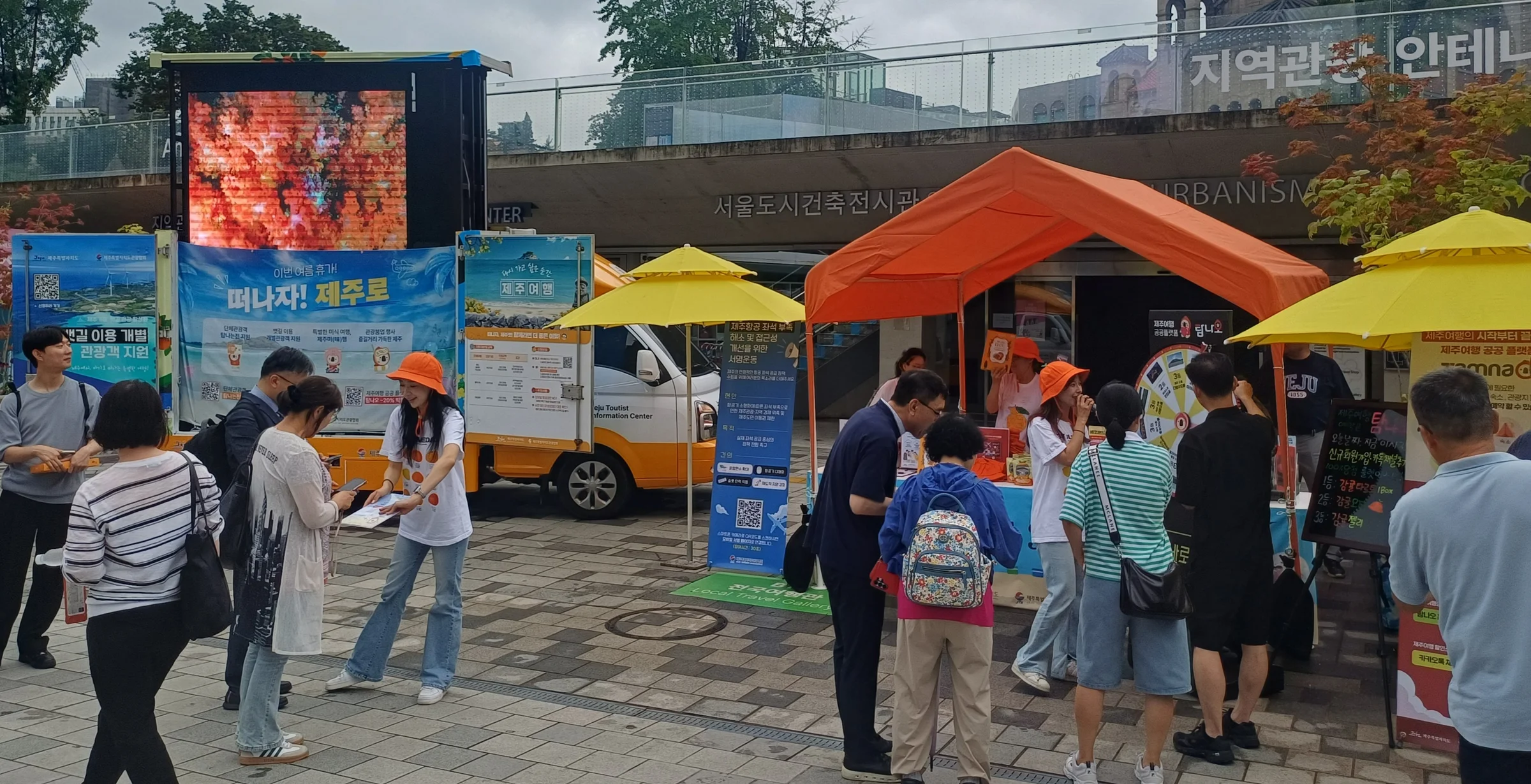 시민들에게 제주관광 홍보 리플릿과 기념품을 배부하는 모습
