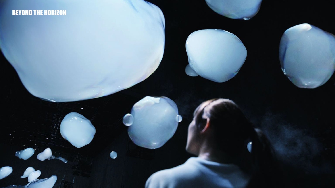 예술과 기술이 만난 'BEYOND THE HORIZON' 전시에서 관람객이 몽환적인 빛의 조형물을 감상하고 있다.